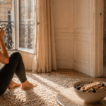 Parisienne élégante dans un appartement lumineux, routine bien-être du matin avec tapis en laine, bol d’açaï et objets lifestyle premium