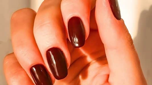 Céline Dion quitte Paris avec une manucure chocolat foncé sur ongles courts, la teinte qui détrône le bordeaux cet hiver